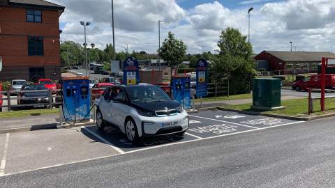 A BMW i3 charging in a designated charging space