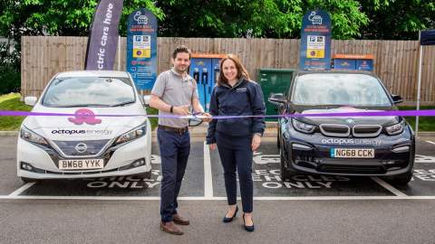 Representitives from Engenie and Octpus Energy cutting a purple ribbon to open their chargers