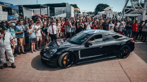 Side view of the Porsche Taycan amonst a croud