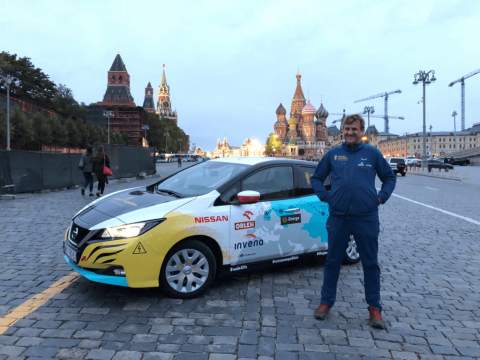 Marek stands next to his new Nissan Leaf