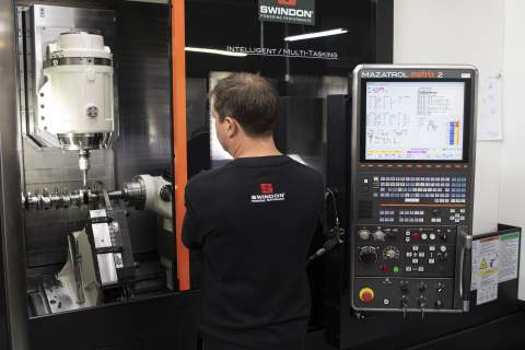 A man creating a car part using CNC