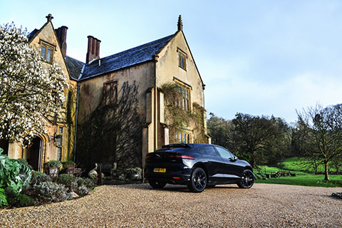 Jaguar I-PACE electric SUV next to a Manor