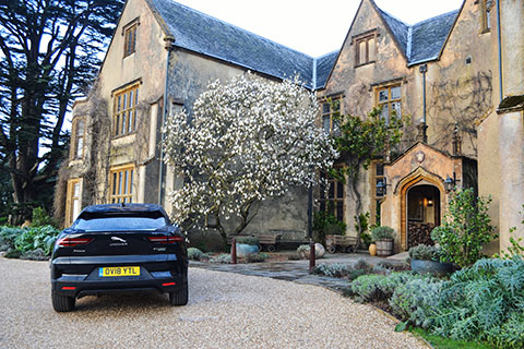 Jaguar I-PACE electric SUV exterior rear view next to a Manor