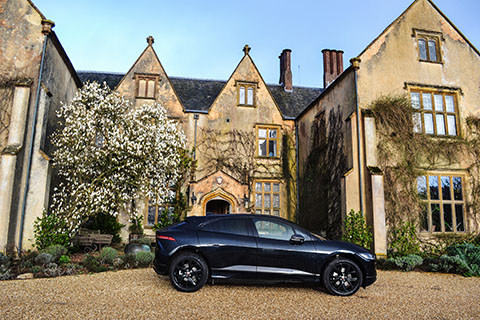 Jaguar I-PACE electric SUV exterior side view next to a Manor