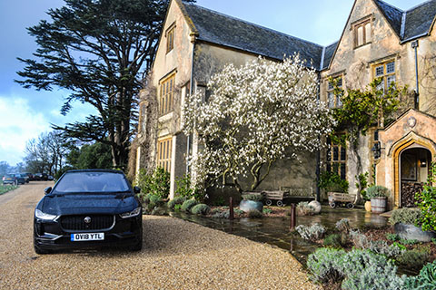 Jaguar I-PACE electric SUV exterior front view next to a Manor